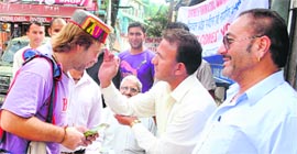 A resident of McLeodganj applies a tilak on the forehead of a foreign tourist on Monday.