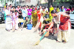 NSS volunteers participate in a cleanliness drive at SCD Government College in Ludhiana on Monday.