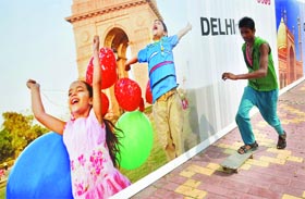A boy skates past a XIX Commonwealth Games poster at a roadside in New Delhi.