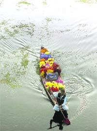 A man carries flowers in his shikara in the Dal Lake in Srinagar