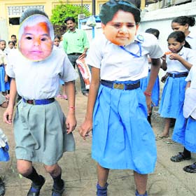Poll gear: School girls with the masks of Mayawati and Lalu Prasad Yadav and in Patna
