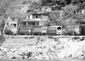 Trucks parked on a damaged road on the way to Almora