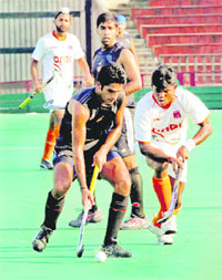 An ONGC player tries to check an IOC opponent during their semifinal at Hockey Stadium, Sector 42, Chandigarh, on Wednesday.