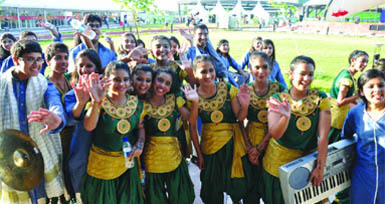 Schoolchildren wave to media persons after the flagging-in ceremony of the South African team at the Commonwealth Village in New Delhi 