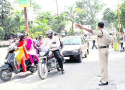 A policeman controls traffic at a busy road that has been made one way in Dehradun.