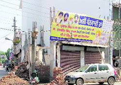 An under-construction commercial building in Gobind Nagar with a huge hoarding carrying pictures of chief minister and deputy chief minister in Ludhiana
