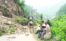 People await clearing of a blockade in Bhaintal block of Nainital