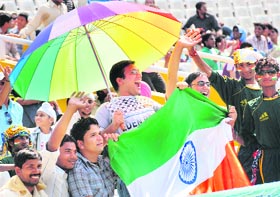 Supporters carrying Indian and Aussie flags cheer for their teams amid thin attendance on the first day of the first Test at the PCA Stadium in Mohali on Friday.