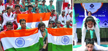 (Left) Volunteers hold the Indian flag during a ceremony to welcome the Indian team to the Games Village in New Delhi on Friday. (Right) Schoolchildren perform at the ceremony.