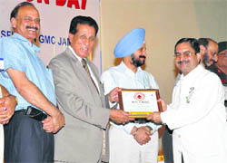 Minister for Medical Education RS Chib presents an award to a donor on National Voluntary Blood Donation Day at Government Medical College and Hospital in Jammu