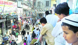 A child standing on a balcony of Jamia Masjid, Malerkotla, looks at people go by in the market after Friday prayers