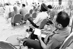 A representative of a real estate agent notes down names of successful applicants during the draw of lots for Aerocity plots in Mohali on Saturday.