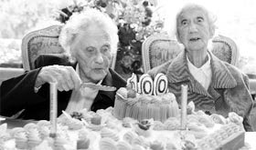 Marie (L) and Gabrielle Vaudremer, 100-year-old Belgian twins, cut a cake as they celebrate their birthday at the Chateau Sous-Bois Retirement Home in Spa on Saturday.
