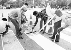 A zebra crossing being repaired ahead of Prince Charles visit at the airport traffic lights in Chandigarh