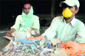A worker shows biomedical waste at the dumping ground in Dadu Majra