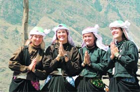 Foreign tourists don local costume at a camp by Mountain Shepherd in Chamoli district