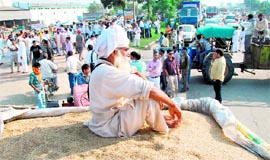Farmers block traffic on NH-1 in Karnal on Sunday.