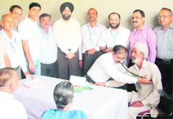 A cardiologist examines a patient during a medical camp at Ahmedgarh on Sunday. 