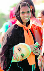 A woman holds a mask of Gujarat Chief Minister Narendra Modi during a municipal body election campaign in Surat on Sunday