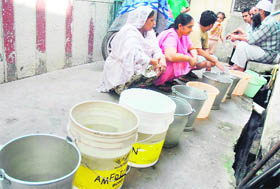 People wait for their turn at a street tap due to water shortage in Patiala, on Sunday. 