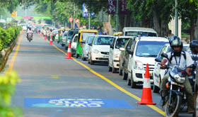 Vehicles steer clear of the Games lane at Sardar Patel Marg in New Delhi on Monday.