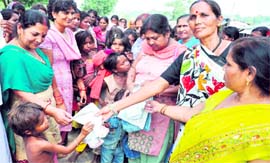 Women activists of the Congress distribute clothes among flood-hit people in Haridwar on Sunday.