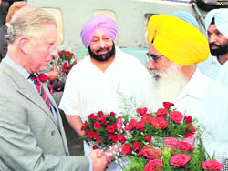 Punjab Information and Public Relations Minister Sewa Singh Sekhwan presents a bouquet to Prince Charles as former Chief Minister Capt Amarinder Singh looks on at the Patiala Aviation Club on Monday