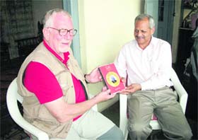 Robert Hutchison, author of Raja of Harsil, presents the copy to local historian Gopal Bhardwaj on the eve of International Writers Festival in Musosorie