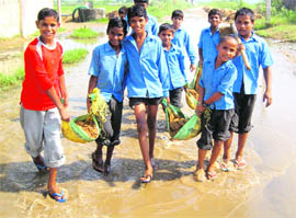 Students of Government Senior Secondary School at Garnawathi village in Rohtak district carry bags of sand inside the school.