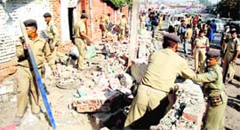 CRPF personnel demolish a bunker in Srinagar on Tuesday.