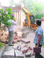 Boundary walls and other concrete structures of houses being razed during a demolition drive by the MC staff in Malerkotla House, Ludhiana