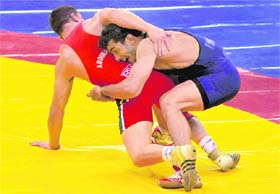 India's Sanjay wrestles with Richard Brian (Red) of South Africa during the final bout of the 74 kg wrestling event at the Commonwealth Games in New Delhi