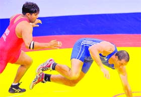 Anil Kumar of India (L) pounces on Hassene Fkiri of Australia on his way to the gold medal in the 96 kg category of the Greco-Roman wrestling at the XIX Commonwealth Games in New Delhi