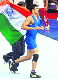 Wrestler Ravinder Singh celebrates after beating Terence Christopher Bosson of England to win gold in 60kg Greco-Roman wrestling event