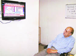 CL Mattoo, the father of Priyadarshini Mattoo, watches a TV news relating to his daughters case in Jammu 