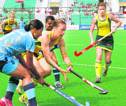 Australias Megan Rivers (C) battles for the ball with Indias Rani Rampal (L) in a group match in New Delhi on Wednesday.