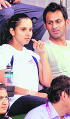 Sania Mirza and her husband Shoaib Malik watch a doubles match between Somdev Devvarman-Rohan Bopanna pair and Scotland's Fleming and Murray during the Commonwealth Games.