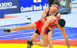 Rajender Kumar (back) competes against Pakistans HUssian Azhar i the 55 kg mens Greco-Roman wrestling final. Kumar won the gold.