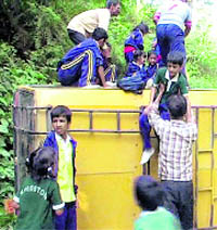 Schoolchildren being taken out from an overturned school bus at Guniyal village near Dehradun on Thursday