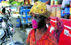 A boy dressed up as Goddess Kali begs in Karnal.