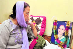 Rajeshwari Mattoo, mother of Priyadarshini Mattoo, looks at her daughters photograph at her house in Jammu on Thursday