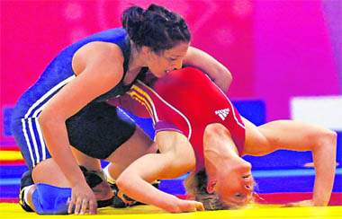 Geeta (in blue) wrestles with Benested Emily of Australia in womens 55kg freestyle wrrestling at the Commenwealth Games in New Delhi on Thursday. Geeta wins gold in the event. 
