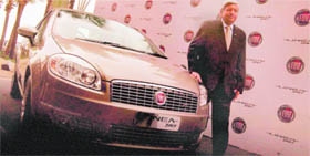 Rajeev Kapoor, President and CEO of Fiat India Automobiles Ltd, poses next the company's new car Linea T- Jet during its launch in Mumbai on Friday.