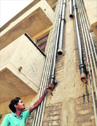 A man points towards the joints from where pipes have been stolen.