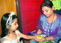 An artist paints on a girls hand in Dehradun