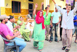 Proud parents and other family members of Vijay Kumar celebrate his victory at Harsour village in Hamirpur