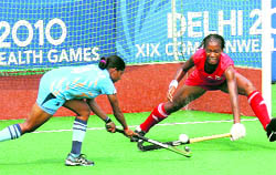 India's Ritu Rani (L) and Trinidad and Tobago's Blair Wynne fight for the ball during their women's hockey group match in New Delhi on Friday
