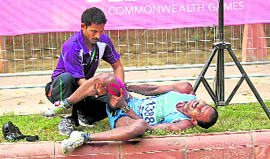 Indias Babu Bhai Panucha being treated on roadside after a muscle cramp during the 20-km walk event of the Commonweath Games on Saturday.