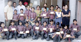 Students of a school showing filled post cards demanding district headquarters status for Fazilka.