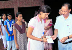 Chief Secretary Subhash Kumar presents scholarship papers to students at 